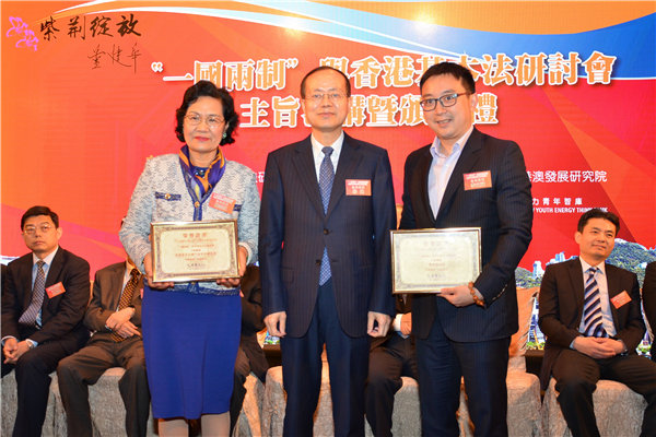 2中央政府驻香港联络办公室杨健（中）副主任为香港新活力青年智库杨志红总监（左）、李文斌主席颁发纪念证书